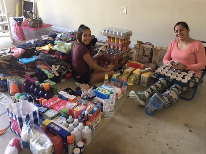 Caitlyn Solei sits with her aunt Brenda Valentin, surrounded by the donations theyve collected for hurricane victims in Puerto Rico. 