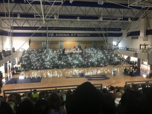 The flashlights of students phones light up the gym to represent the many people who have been affected by cancer.