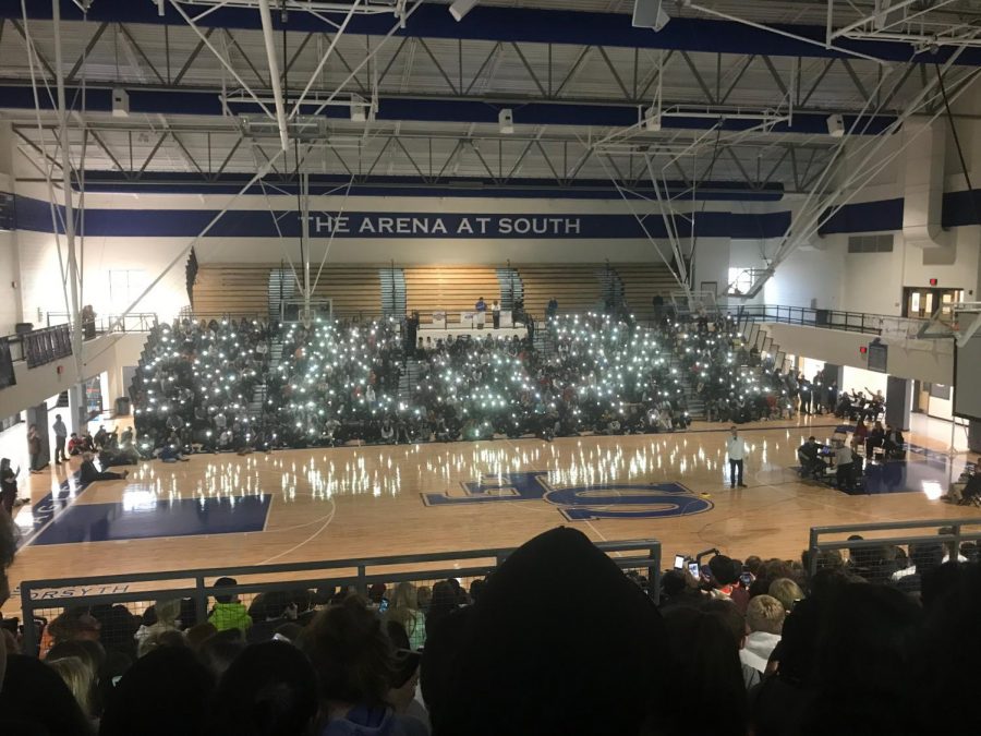 The flashlights of students phones light up the gym to represent the many people who have been affected by cancer.