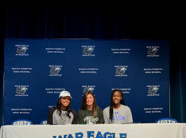 South volleyball players, Hannah McGlockton, Jessica Beil, and Sydney Bibby (Left to right), sit awaiting their chance to sign into their college career. 