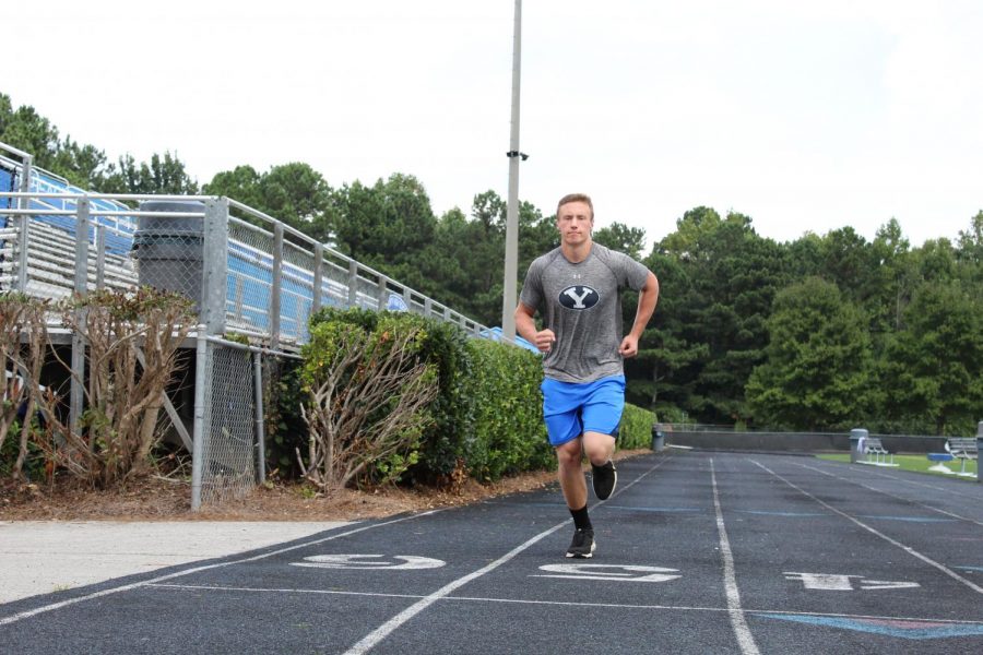 Taft Hilton, a varsity football player, runs the track at South Forsyth to warm up before practice.