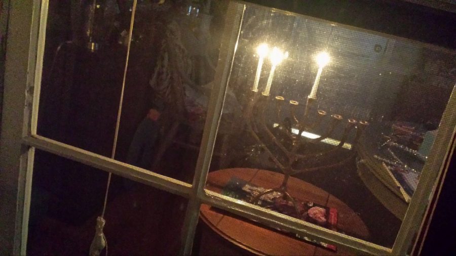 A glow in the window. The menorah is the traditional candle holder for Hanukkah; 9 candles are lit for each day of the holiday.