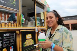 Keep palm and carry on. Junior Monica Ramos receives her complementary Kona ice at the DECA tailgate. The club wanted to encourage students to show school spirit at the game. I had so much fun hanging out with my friends and playing in the bouncy house. Ramos said.