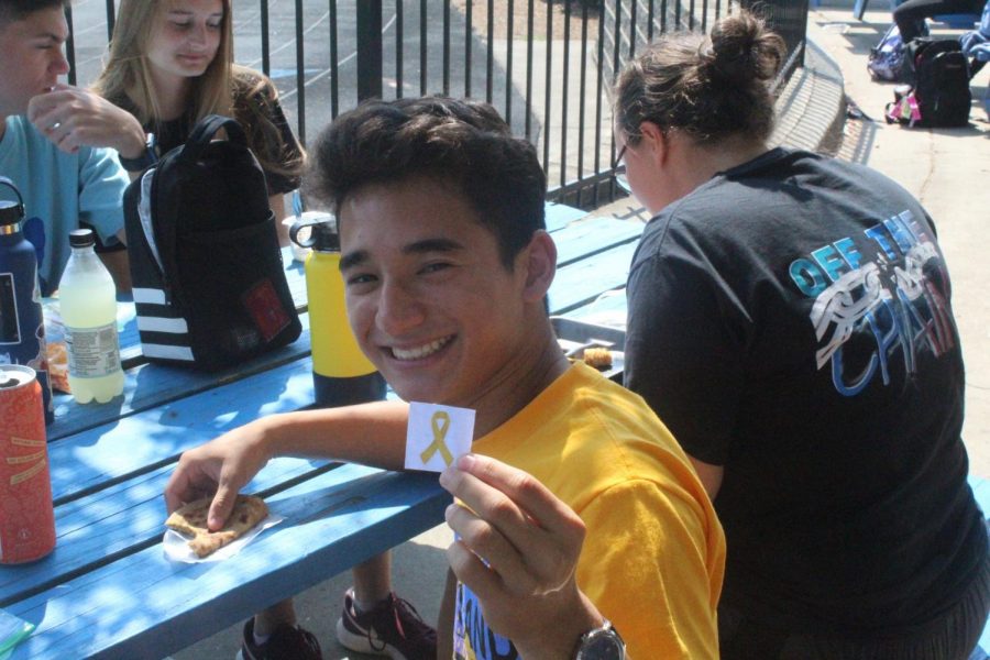 Yellow for Remembrance. Senior Matthew Trinh proudly holds up a yellow ribbon in honor of his support on such a day.