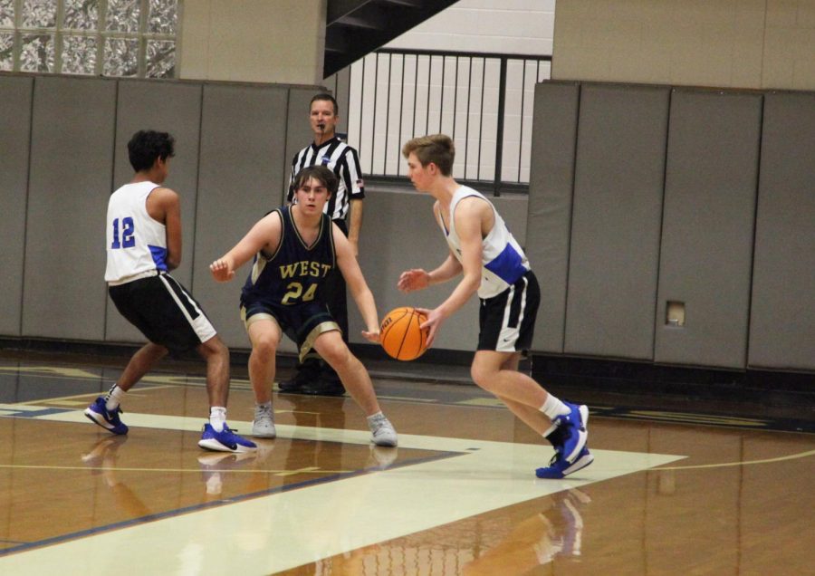 Taking Charge. Freshman Drew Bramwell faces off in the game against West Forsyth. Bramwell crossed over the guard to lead the way to the basket.