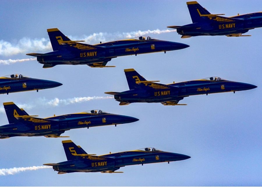 The Blue Angels and Thunderbirds flying over Roswell, GA. Bystanders stood and stared up at the sky watching the planes overhead. 
