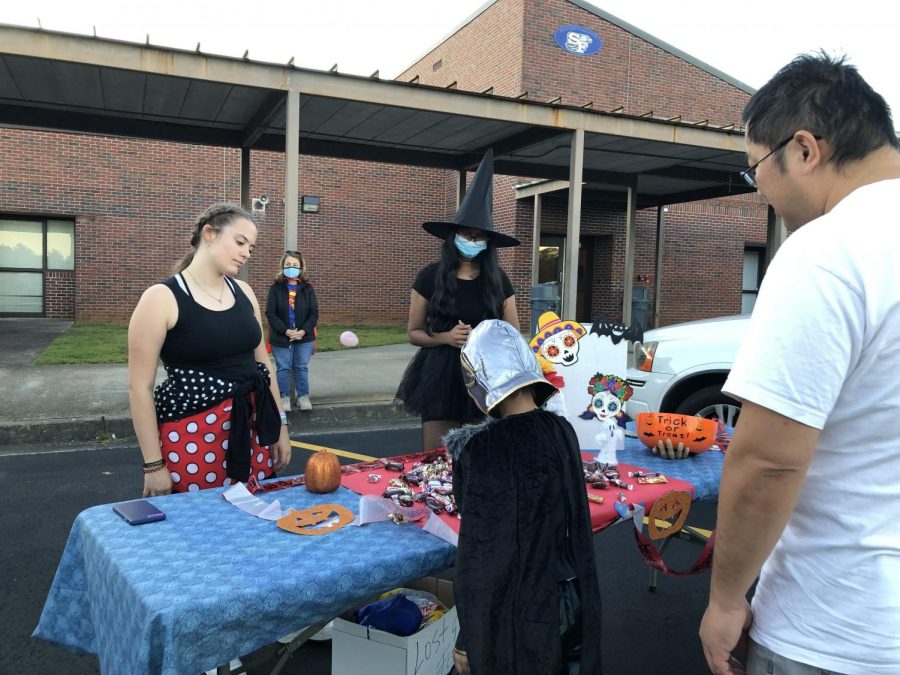 Sweet service. SFHS Key Club members and officer volunteer to hand out candy during Trunk or Treat. The childrens left this table with huge smiles as they recieved a handful of candy.