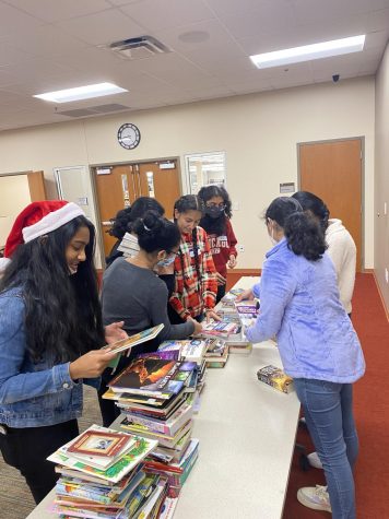 Joyful community service. Students organized hundreds of books, in several different stacks. These books were sent to the Toys-for-Tots foundation, and filled members with a sense of community and gratitude, 