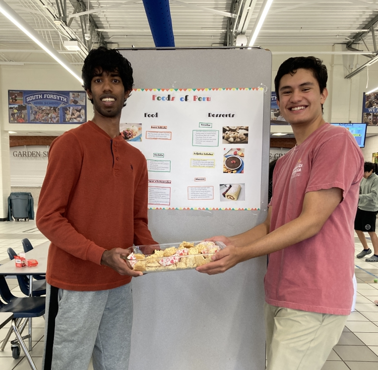 Francisco Valentinotti and Royce Arockiasamy show the coconut dessert they brought to exhibit a sample of Perus food. Thirteen countries were represented at the Hispanic Heritage Festival.