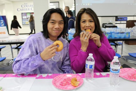 South junior Matt Craig, and his mother, Sheila, enjoy their donuts in the dining hall. The mother and son duo came to school early to partake in the Donut Date.